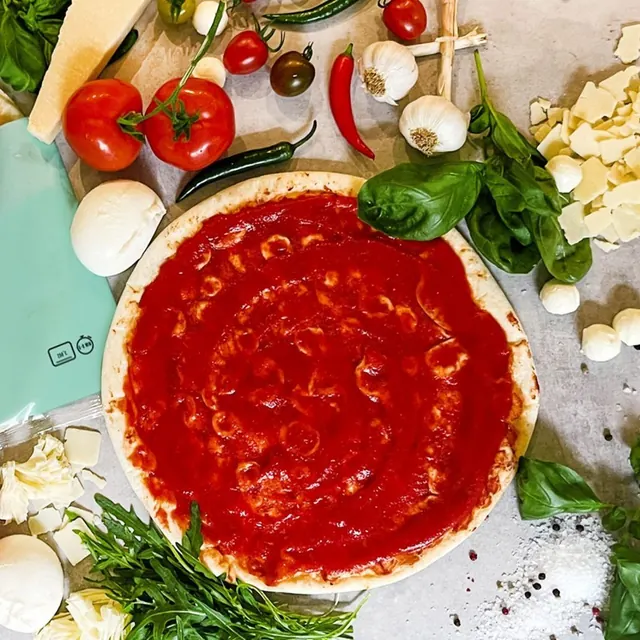 Mama Ria Pizzaboden, bereits mit Tomatensauce bestrichen